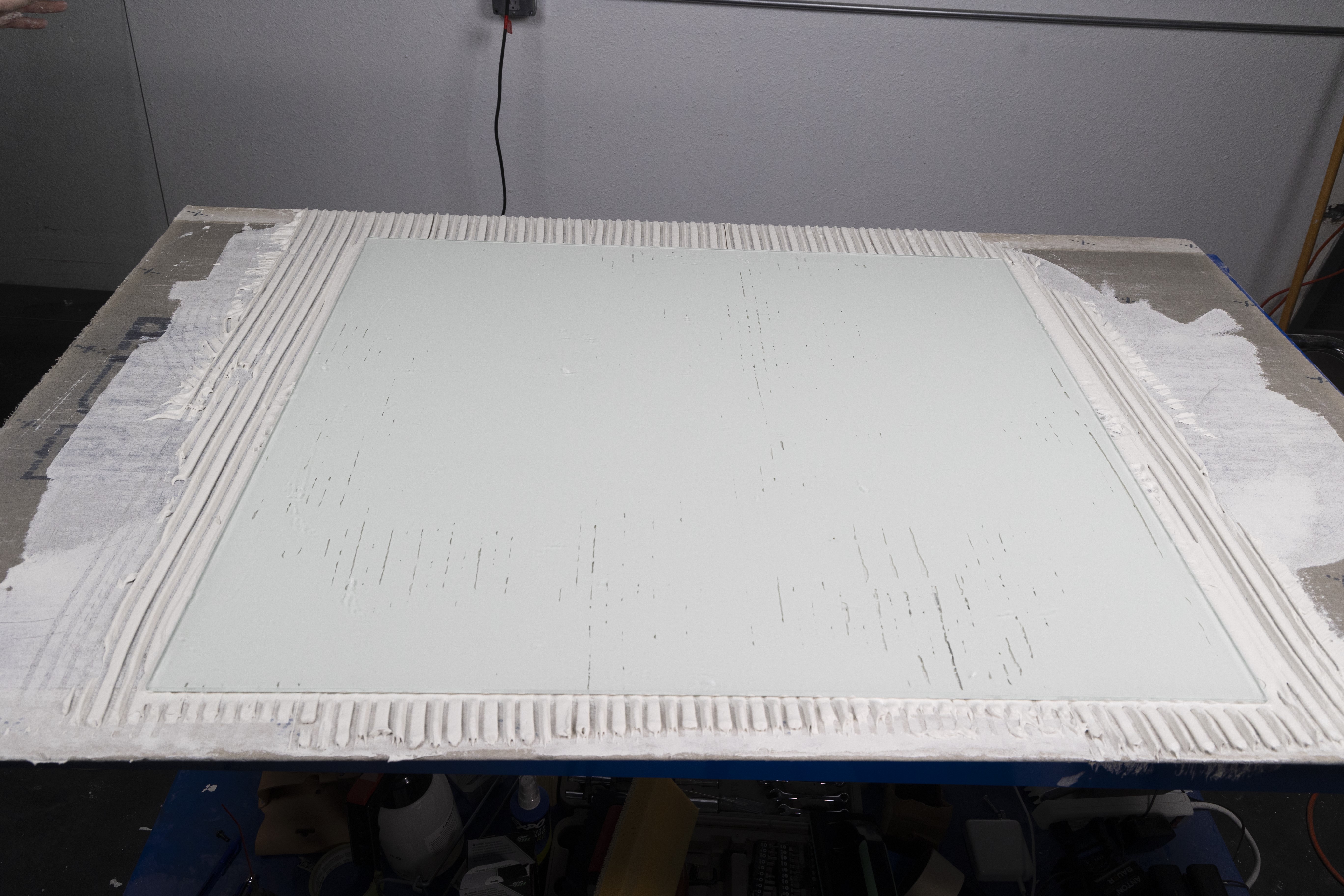 large glass tile shows the coverage rates of the Euro Notched Trowel
